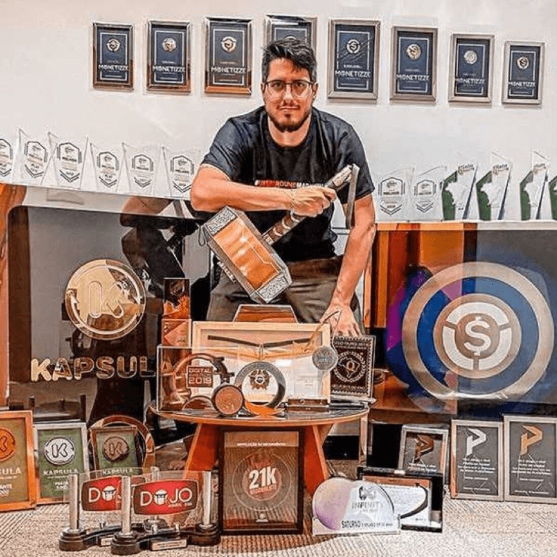 Marcio Marçal cercado por dezenas de prêmios